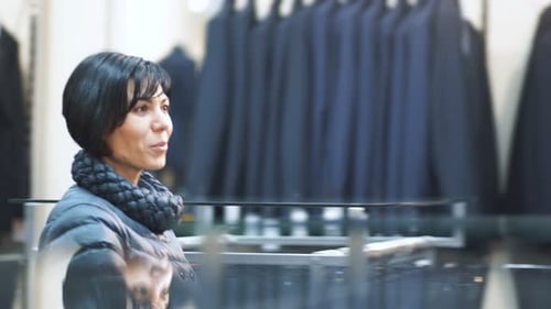 Woman shopping for clothes, looking at menswear suits