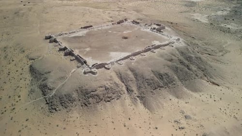 Historic Desert Fortress Surrounded By Cliffs and Dry Shrubland
