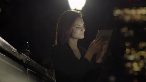 Young Woman Using Tablet Computer In The Park At Night