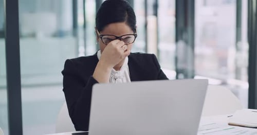 Businesswoman Rubbing Eyes While Working at Computer