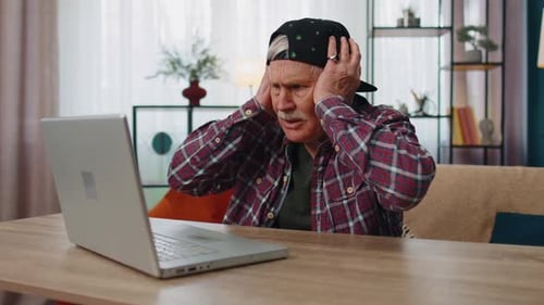 Senior Man Frustrated with Laptop Computer at Home