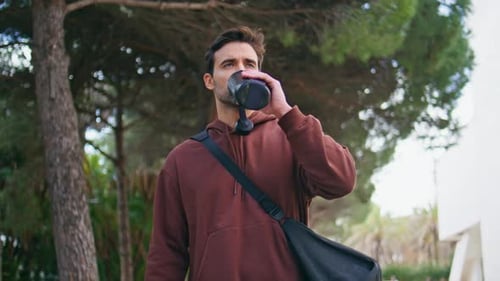 Man Drinks Water After Workout in City Park