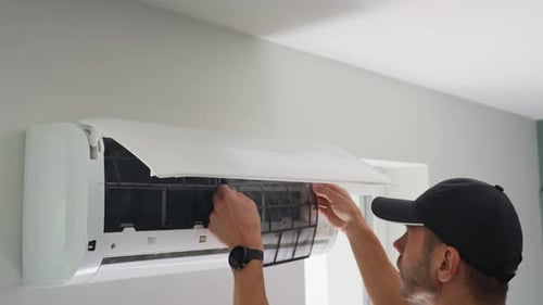 Man Removes Air Conditioning Filter for Cleaning