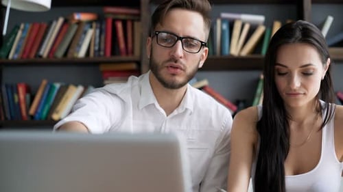 Two Students Brainstorming Work by Discuss with Desktop in Hipster Loft Closeup