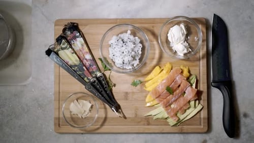 Display of ingredients for Sushi with falling fresh green herbs seen from top down on kitchen counte