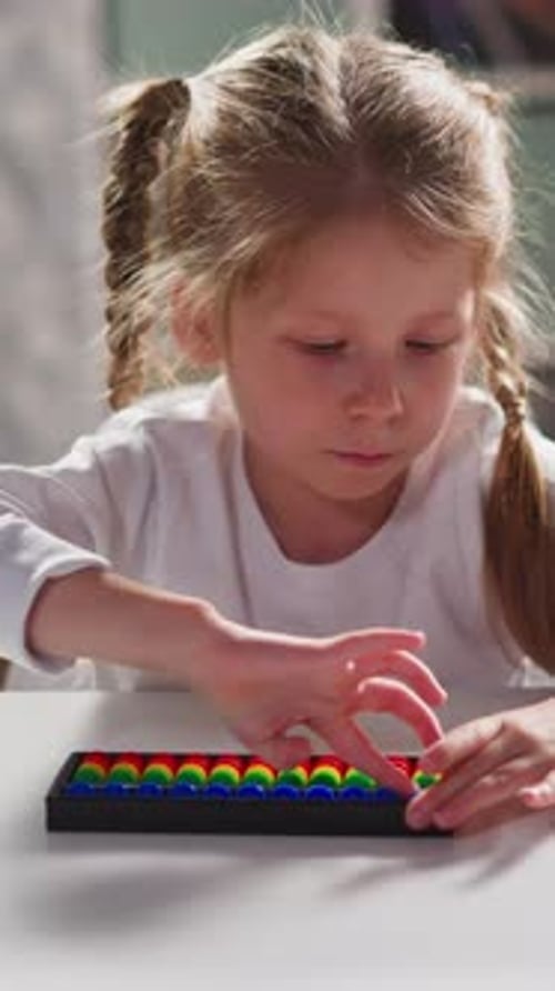Un pequeño estudiante aprende a resolver tareas con Abacus at Desk