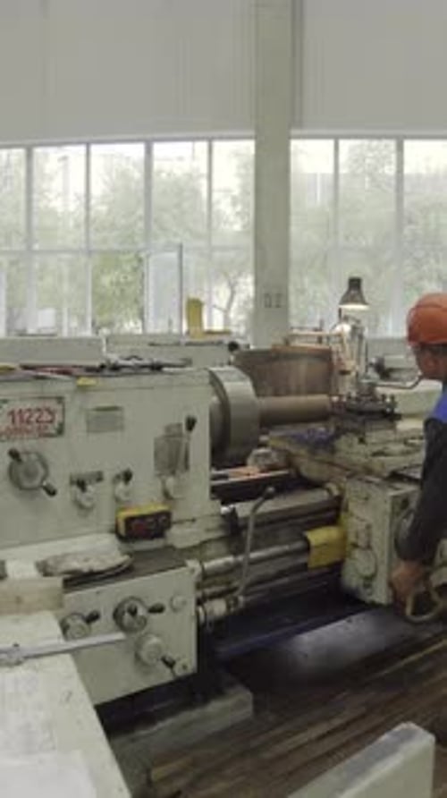 Factory Worker Operating Lathe Machine in Manufacturing Plant Stock Clip