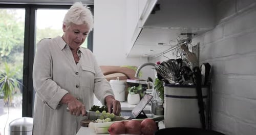 Woman Cooking with Tablet in Bright Kitchen