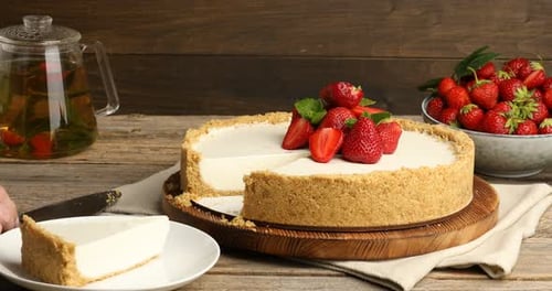 Cheesecake slice presented with strawberries and tea