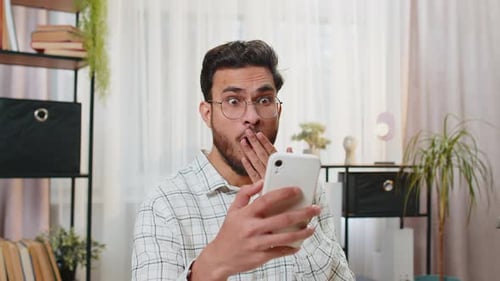 Young Adult Celebrates While Looking at Smartphone