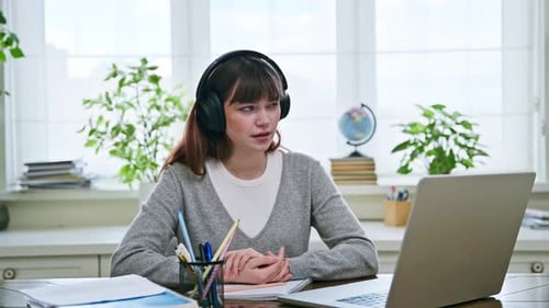 Woman Video Conferencing At Desk With Laptop