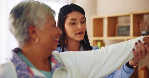Young Woman Assists Senior with Arm Exercise