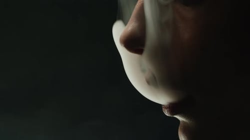 Young Woman Smoking Hookah or Cigarette on Black Background Closeup Smoke Vapour and Fog Texture