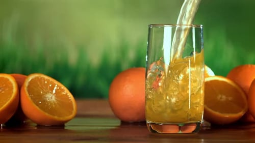 Orange Juice Pour with Fresh Oranges on Table