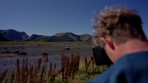 Man Photographing Mountain Landscape on a Sunny Day