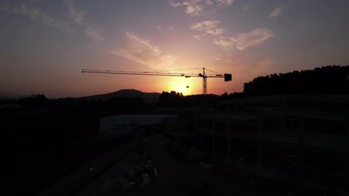 Chantier avec grues au coucher du soleil