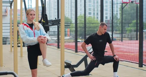 Two People Stretching at Outdoor Urban Workout Park