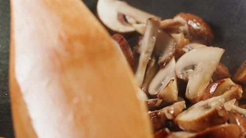 Chef Cooking Mushrooms on Wok Frying Pan Close Up Champignons Mushroom with Salt in Pan Restaurant