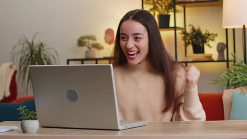 Woman Receives Good News on Laptop and Celebrates