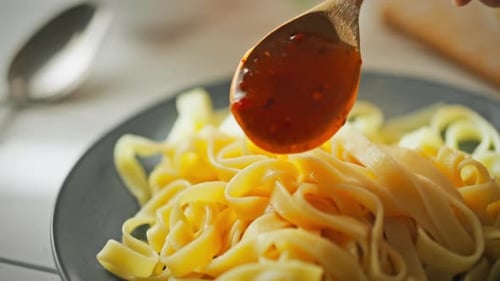 Pouring Sauce on Delicious Looking Pasta Noodles