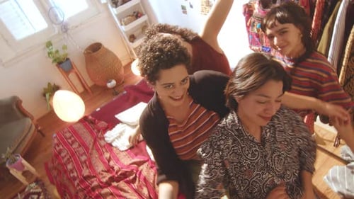 Cheerful Friends Smiling Indoors with Wardrobe