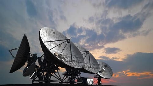 Satellite Dishes Against a Colorful Sunset