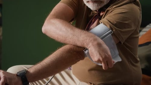 Senior Man Checks His Blood Pressure at Home