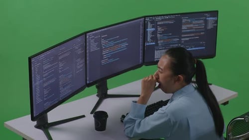 Tired Asian Woman Yawning Before Sleeping While Write Code With Multiple Computer In Green Screen