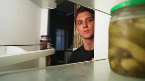 Young Adult Man Looking Inside Refrigerator