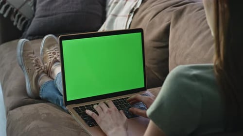 Woman Typing Green Screen Laptop at Comfortable Couch Closeup Female Freelancer