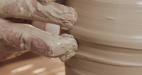Hands Shape Clay on Spinning Pottery Wheel Close Up