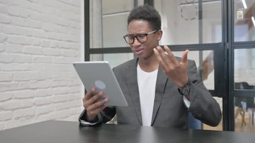 Man Reacts with Shock to Tablet in Office