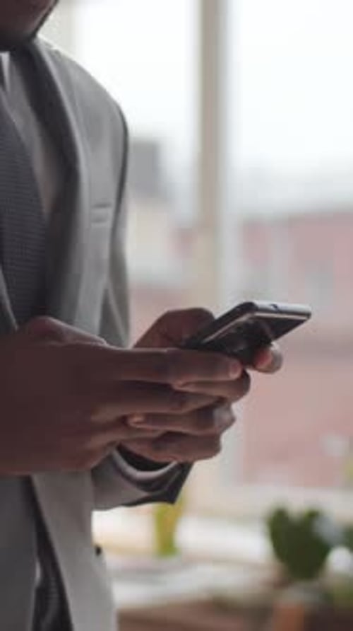Businessman Typing Message of Smartphone in Office