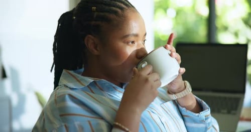 Woman Drinking Coffee, Relaxing Indoors, Laptop in Background