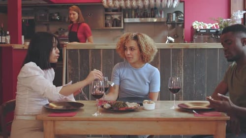 diverse group of friends is enjoying meal together at restaurant