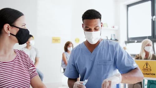 Healthcare Worker Giving Vaccine to Woman in Clinic