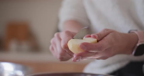 Woman Peels Apples In Kitchen