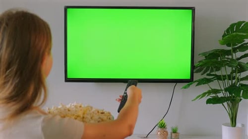 Woman Holding Bowl of Popcorn While Watching Green Screen Television