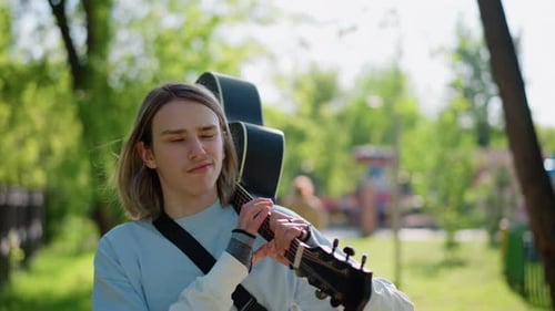 Casual Guitarist Enjoying Nature Walk Relaxed String Player Exploring Scenic Park Surroundings