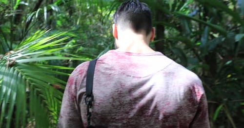 Young Man Exploring Lush Jungle on Hiking Adventure