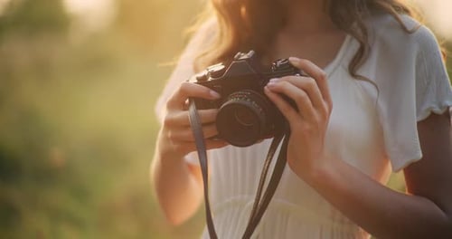 Young Woman Holding Camera in Golden Light