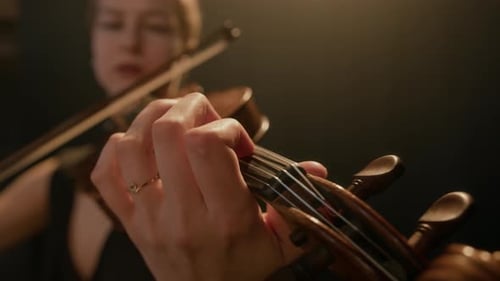 Woman Plays Violin in Dramatic Lighting