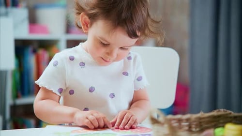 Cute Girl Pasting Shapes at Table in Bright Room