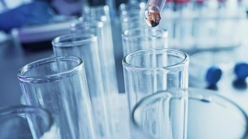 Dropper and test tubes in a laboratory setting