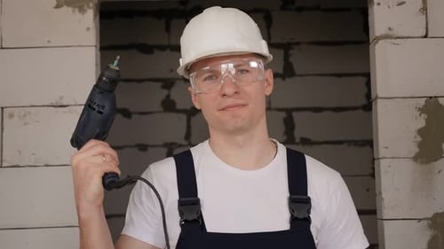 Construction Worker Holding Drill at Building Site
