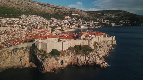 Old St Lawrence Fortress with Neat Town on Steep Cliff Against Mountains
