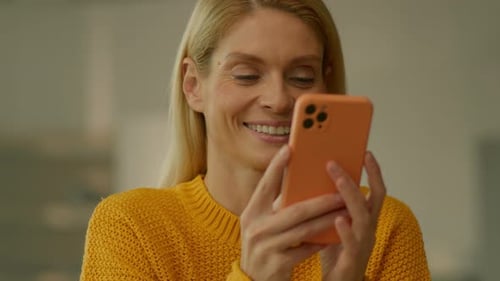 Close Up Smiling Woman Hold Use Smartphone Sitting at Home Scrolling Social Media Camera Moving