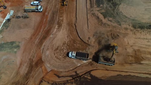 Excavator Filling Dump Truck at Rural Construction Site