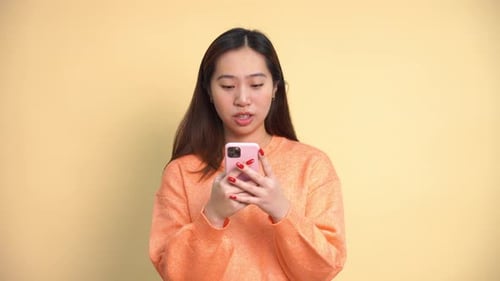 Young Woman Uses Phone with Surprised Expression