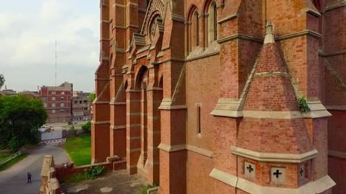 Close up aerial view of A beautiful old Church, A cross on the Church building, Traffic is moving on